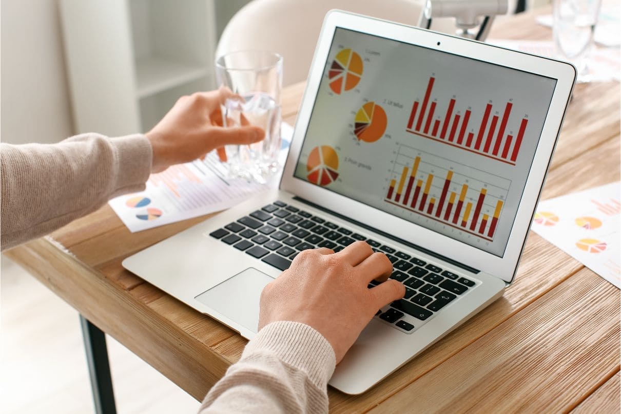 A person analyzing graphs on a laptop